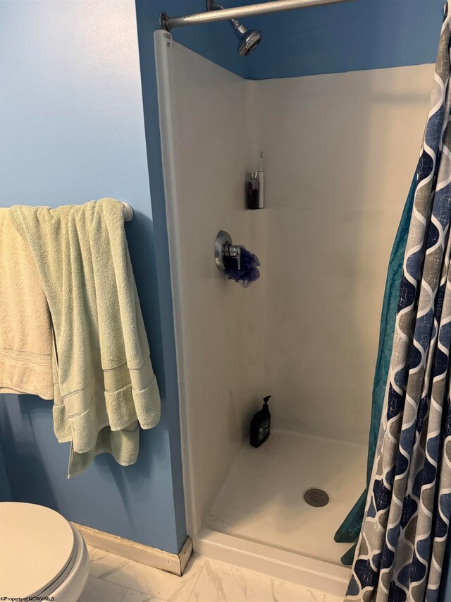 bathroom featuring walk in shower, toilet, and tile patterned floors