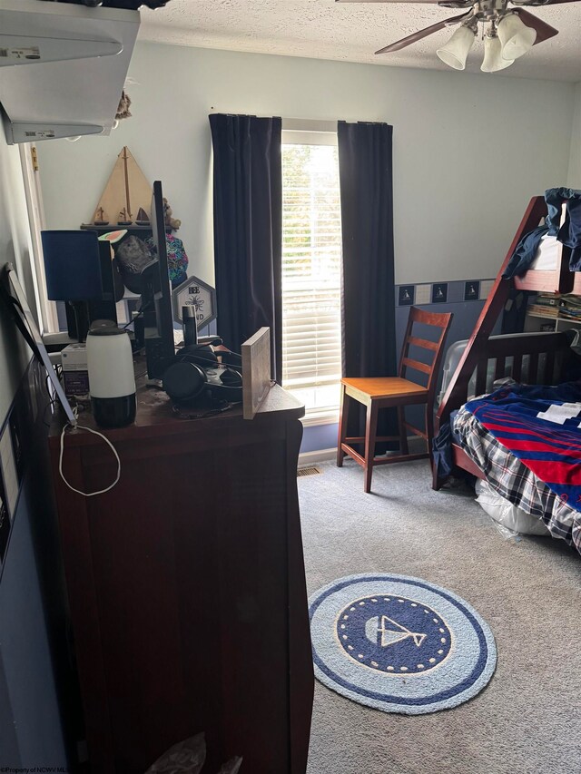 carpeted bedroom with a ceiling fan and a textured ceiling