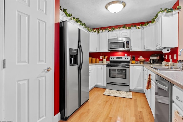 kitchen featuring white cabinets, appliances with stainless steel finishes, and sink