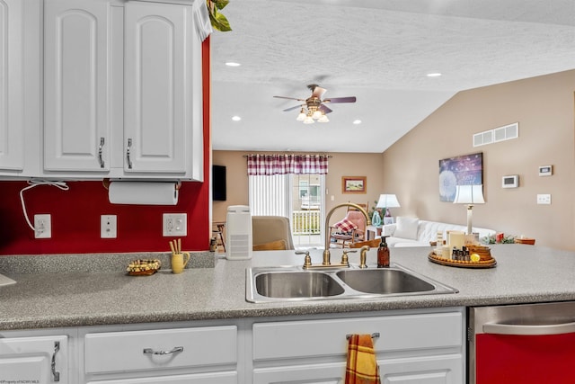 kitchen with sink, white cabinets, vaulted ceiling, ceiling fan, and stainless steel dishwasher