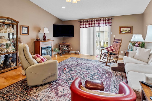 living room featuring wood-type flooring and vaulted ceiling