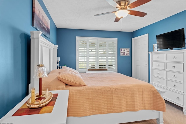 bedroom featuring carpet floors, a textured ceiling, and ceiling fan