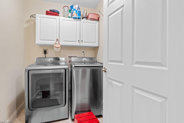 laundry room featuring washer and clothes dryer and cabinets