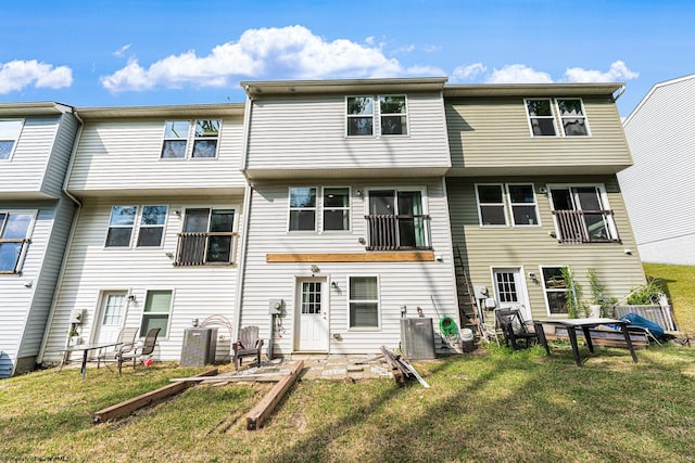 back of house featuring a yard and a balcony