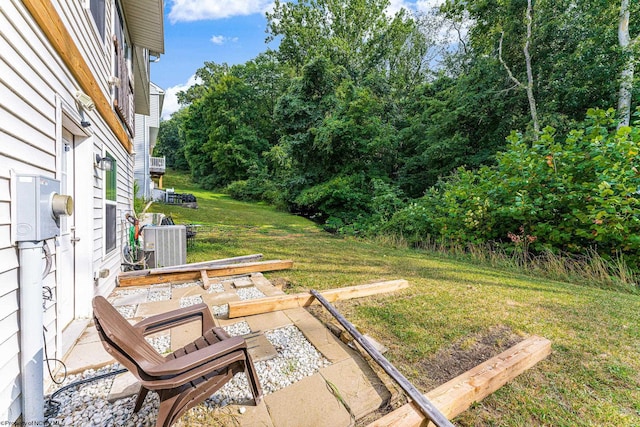 view of yard with central AC unit and a patio area