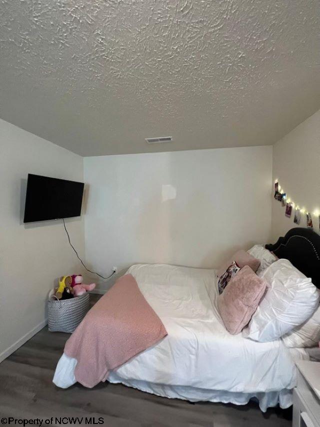 bedroom featuring a textured ceiling and hardwood / wood-style floors