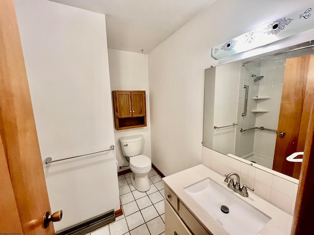 bathroom featuring tile patterned floors, tiled shower, vanity, and toilet