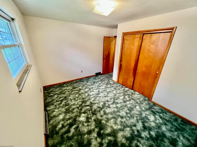 unfurnished bedroom with carpet floors and a closet