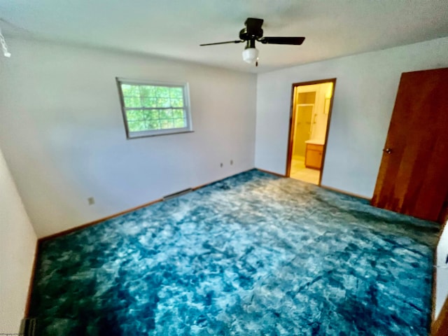 unfurnished bedroom with connected bathroom, carpet, and ceiling fan