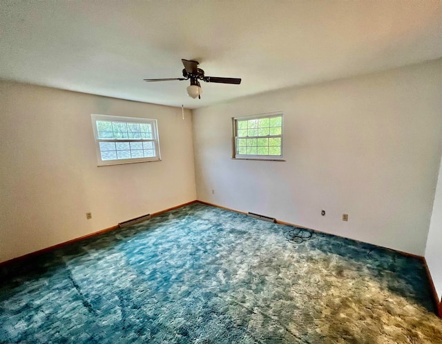 empty room featuring ceiling fan, carpet floors, and a wealth of natural light