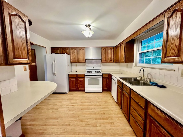 kitchen featuring sink, white appliances, tasteful backsplash, light hardwood / wood-style flooring, and wall chimney exhaust hood