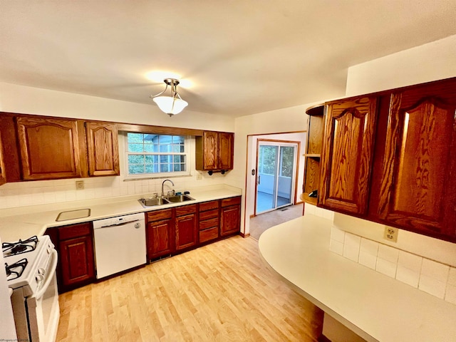 kitchen featuring light hardwood / wood-style flooring, a wealth of natural light, white appliances, and sink