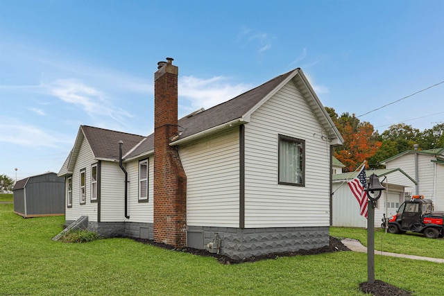 view of side of home featuring a lawn and a storage shed