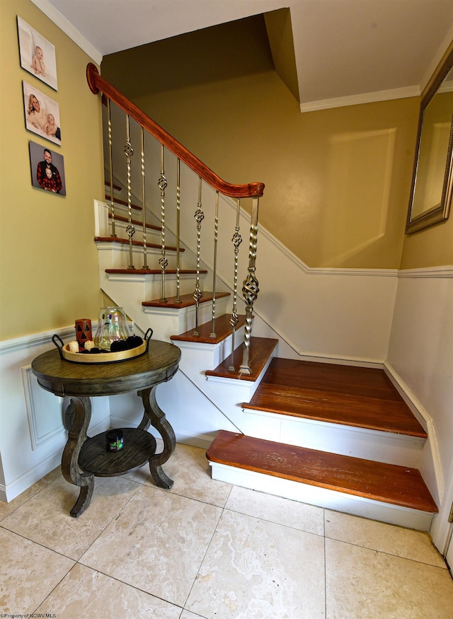 staircase with crown molding and tile patterned flooring