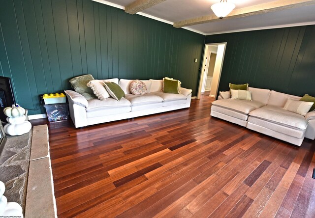 living room with beam ceiling, wood walls, and dark wood-type flooring