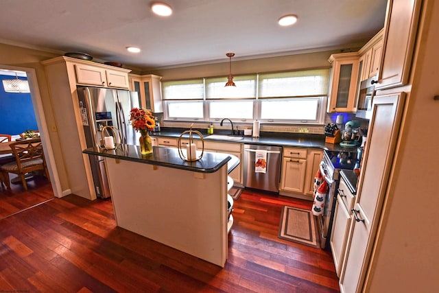 kitchen featuring appliances with stainless steel finishes, dark hardwood / wood-style flooring, pendant lighting, a center island, and sink