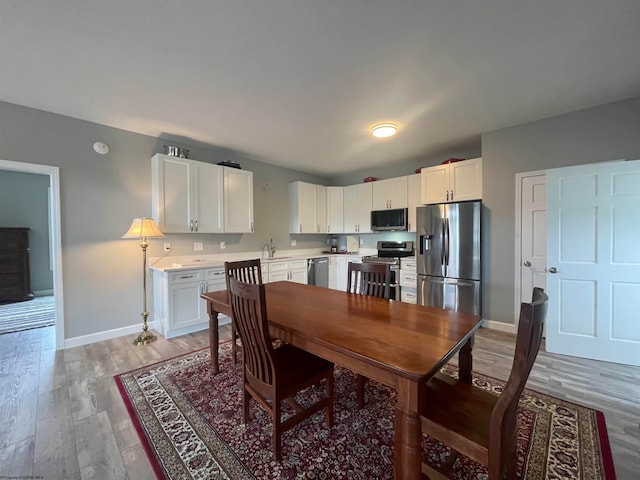 dining area featuring sink and light hardwood / wood-style floors