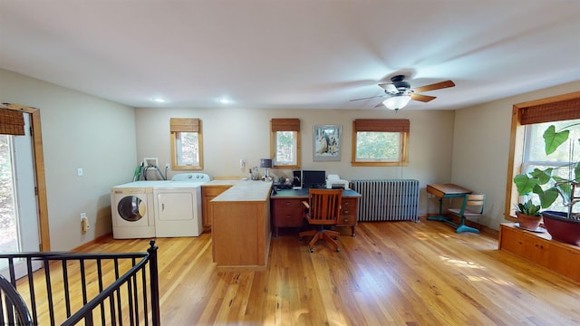 home office with radiator, plenty of natural light, light hardwood / wood-style floors, and washing machine and clothes dryer