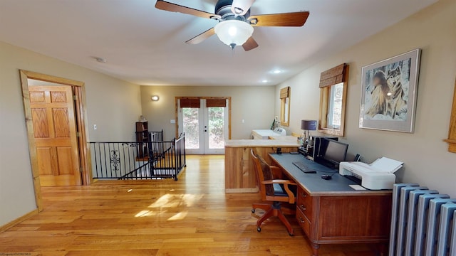 office area featuring french doors, radiator, light wood-type flooring, and ceiling fan