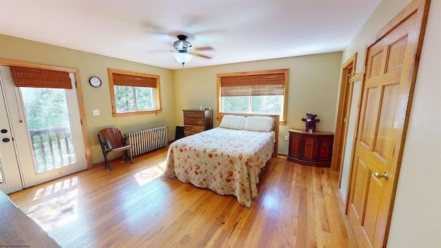 bedroom with radiator, light hardwood / wood-style floors, ceiling fan, and access to outside