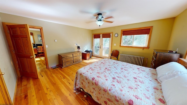 bedroom featuring ceiling fan, access to outside, radiator heating unit, french doors, and light hardwood / wood-style flooring