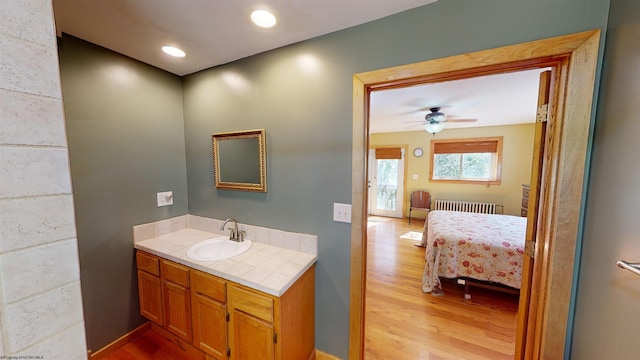 bathroom with radiator, ceiling fan, vanity, and hardwood / wood-style flooring