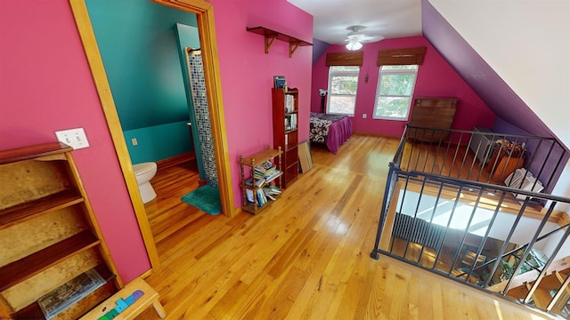 hall with vaulted ceiling and hardwood / wood-style floors