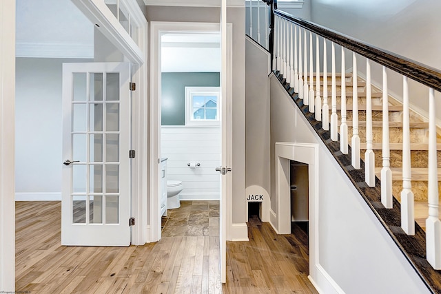 stairs featuring wood-type flooring and ornamental molding