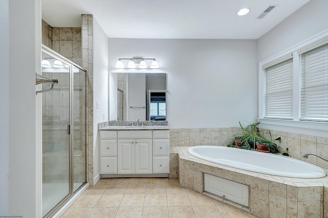 bathroom with plus walk in shower, tile patterned flooring, and vanity