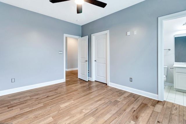 unfurnished bedroom with light wood-type flooring, connected bathroom, and ceiling fan