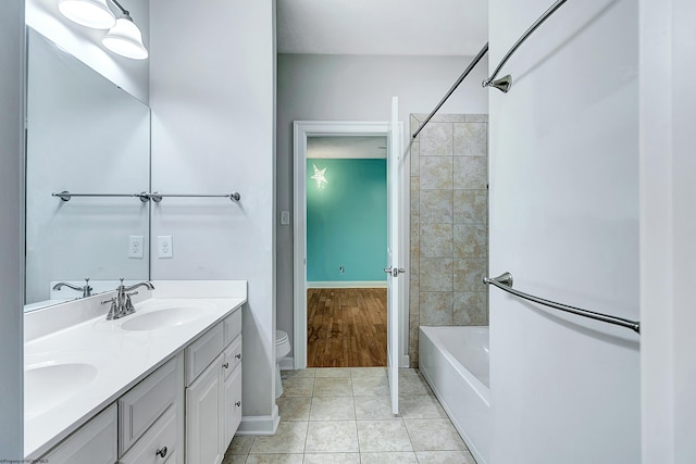 full bathroom with tiled shower / bath, vanity, tile patterned flooring, and toilet