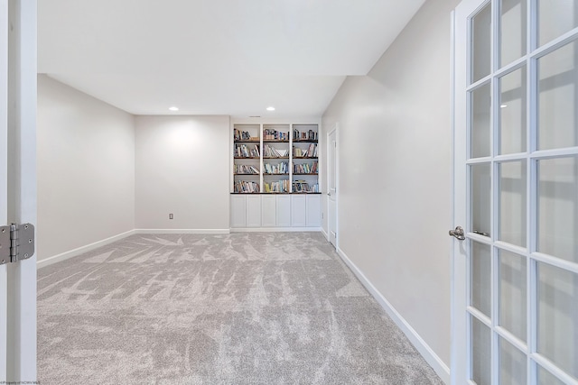 carpeted spare room featuring built in shelves