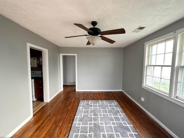 unfurnished room featuring a textured ceiling, a baseboard heating unit, dark hardwood / wood-style floors, and ceiling fan