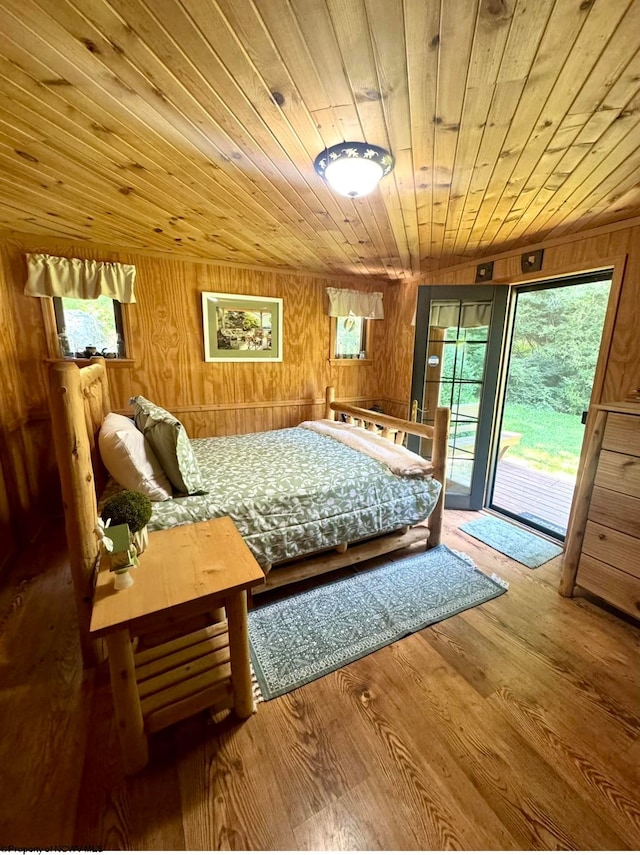 bedroom with vaulted ceiling, wooden ceiling, wood-type flooring, access to outside, and wooden walls