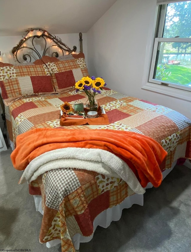 bedroom with vaulted ceiling and carpet flooring