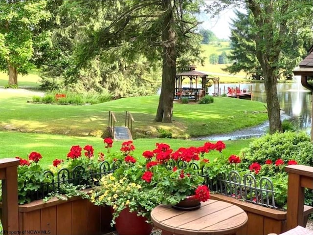 view of community with a lawn, a gazebo, and a water view