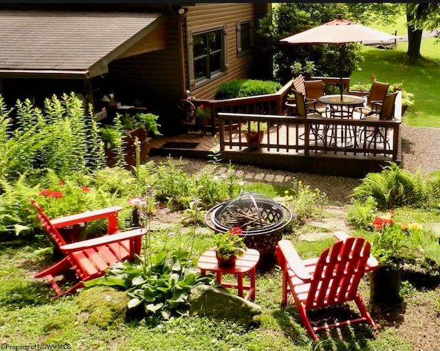 view of yard featuring a wooden deck and a fire pit