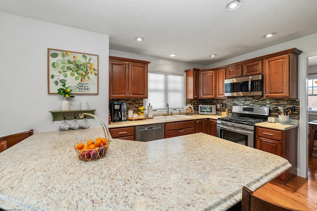 kitchen featuring a kitchen breakfast bar, a wealth of natural light, kitchen peninsula, and appliances with stainless steel finishes