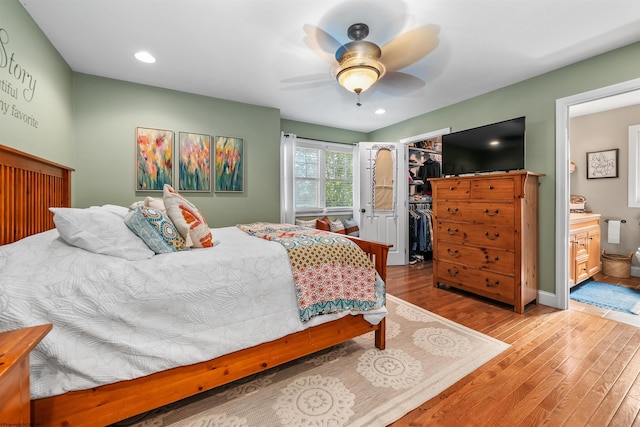 bedroom with ceiling fan, hardwood / wood-style flooring, a closet, a spacious closet, and ensuite bathroom