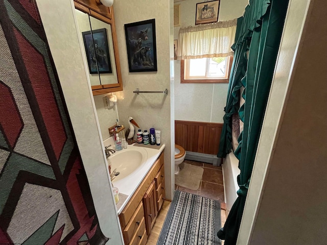 full bathroom with vanity, shower / bath combo with shower curtain, toilet, and a baseboard heating unit