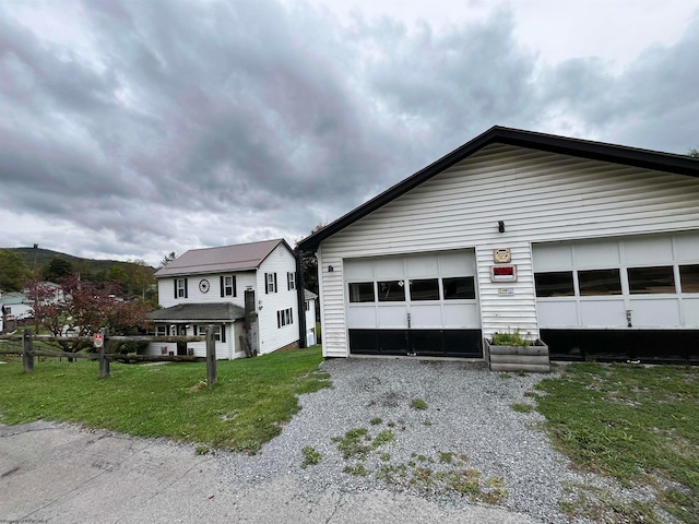 view of front of house featuring a front yard, an outbuilding, and a garage