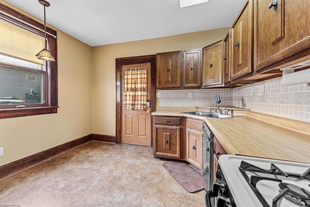 kitchen with pendant lighting, sink, tasteful backsplash, and white gas range oven