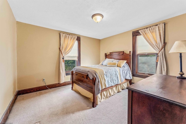 bedroom featuring light carpet and a textured ceiling