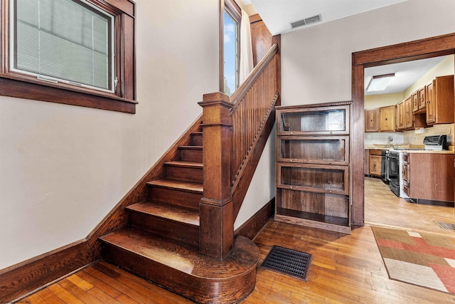 stairway with hardwood / wood-style flooring and sink