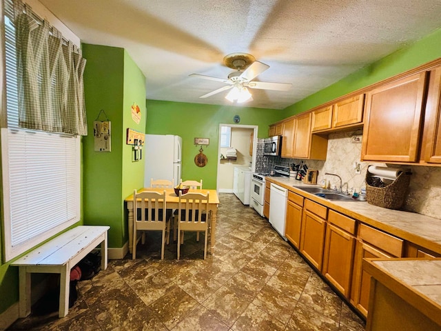 kitchen featuring a textured ceiling, sink, white appliances, tile countertops, and ceiling fan