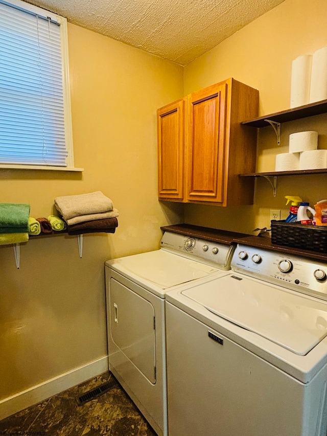 laundry area featuring cabinets, independent washer and dryer, and a textured ceiling