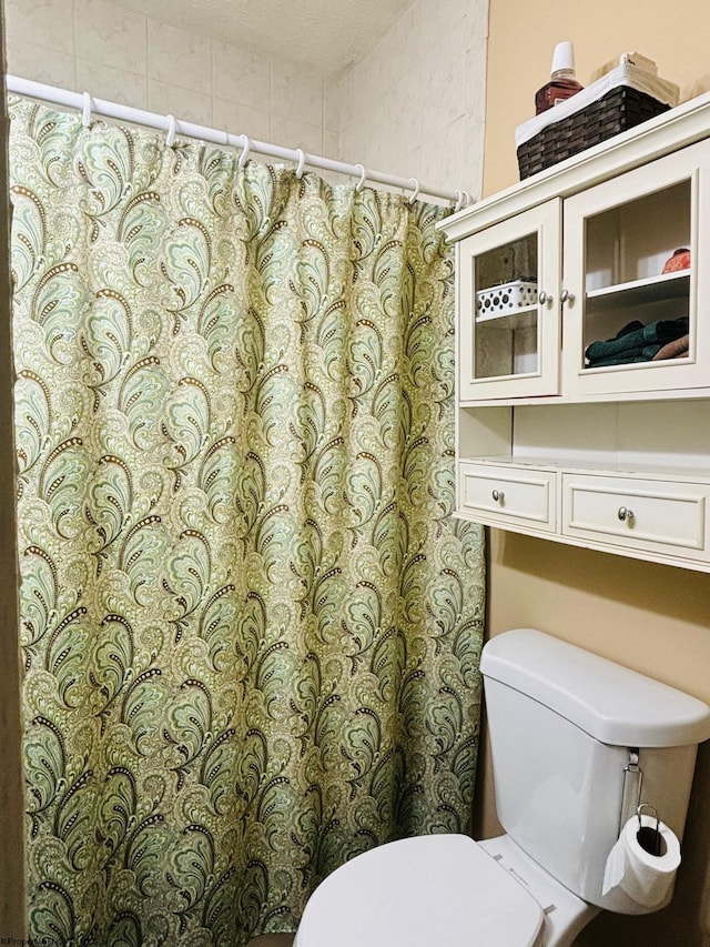 bathroom with a shower with curtain and toilet