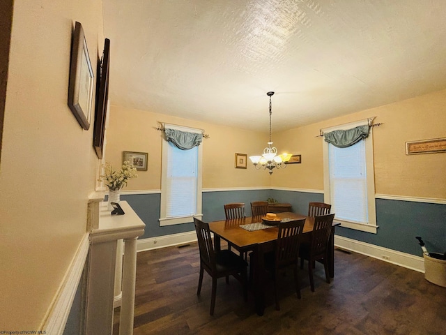 dining space featuring dark hardwood / wood-style floors and a chandelier