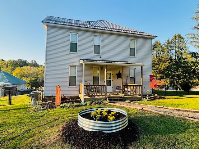 rear view of property featuring a lawn