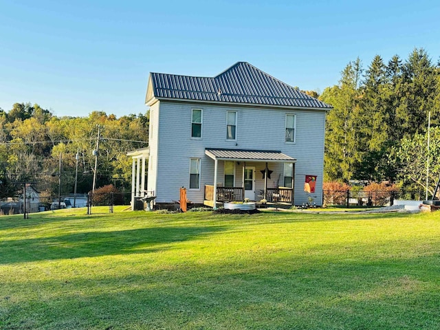 back of property featuring a lawn and covered porch